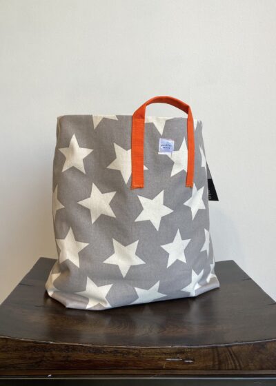 A Grey Color Bag With White Stars and Orange Strap